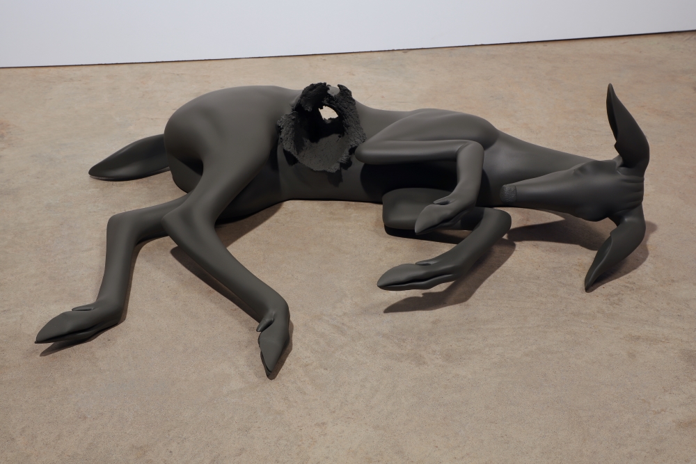 Jessica Teckemeyer A painted polyurethane 3-dimensional fawn lays on its side with a circular shot through the belly