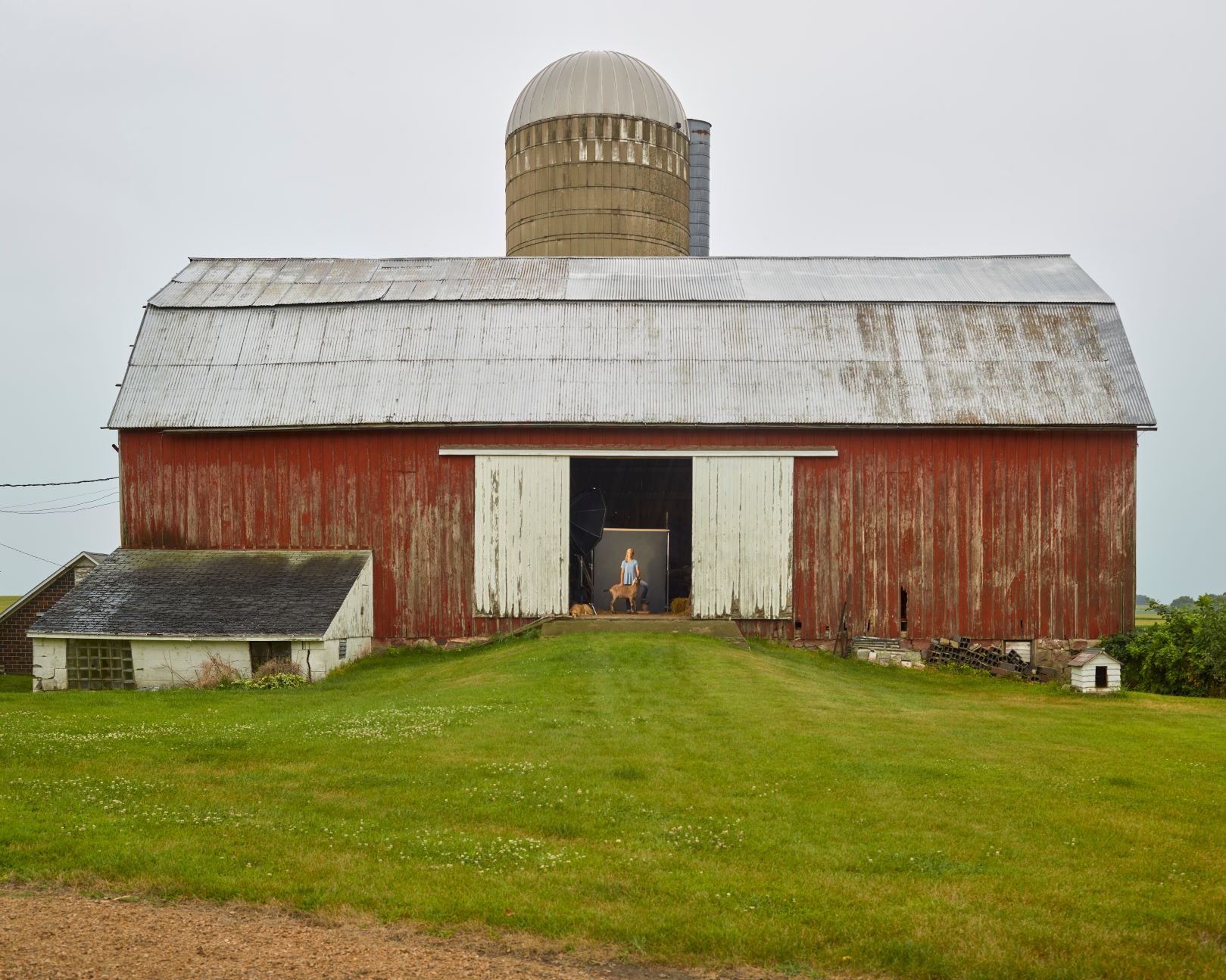 R. J. Kern A person poses with an animal near barn.